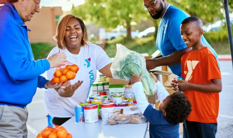 Community volunteers gathering donated food on table outside