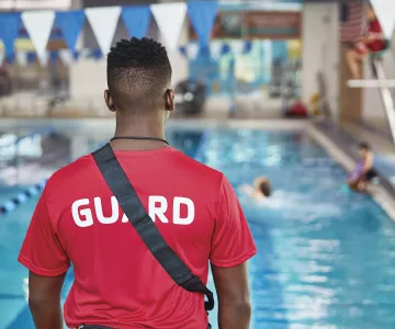 Lifeguard watching the pool to ensure safety in and around the water