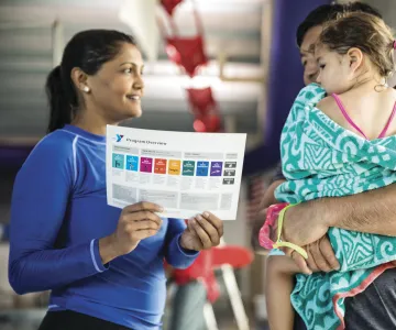 Swim instructor talking with parent and child about swimming skills