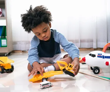 Happy black people African American child play truck and airplane toy
