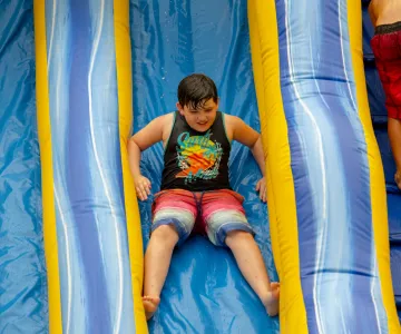 Boy going down an inflatable water slide