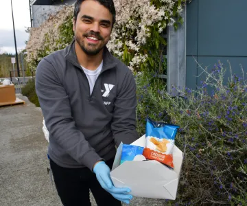 Staff holding a box lunch donation for families in need