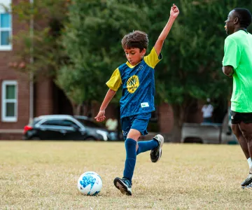 Boy playing soccer about to kick the ball