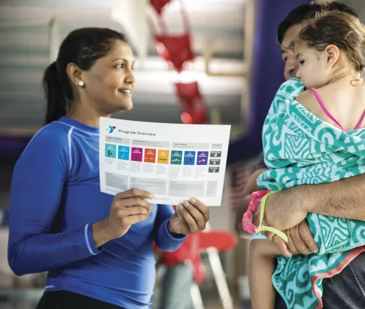 Swim instructor talking with parent and child about swimming skills