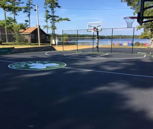 Basketball court at camp Yomechas with Celtics logo on the center court line