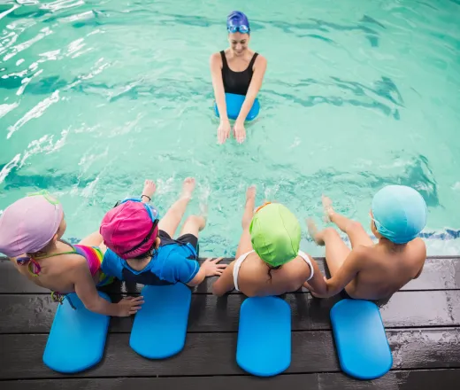 Cute swimming class watching their swim instuctor