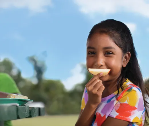 child eating apple outside