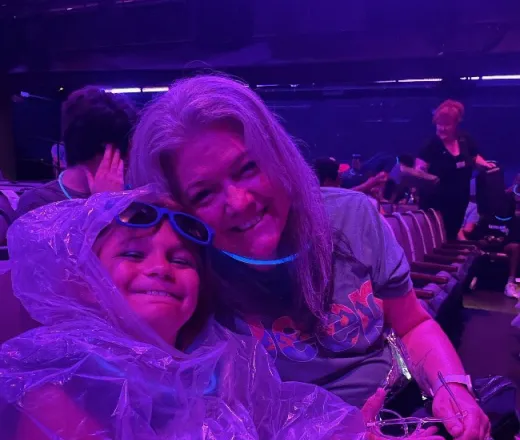 Smiling kid in a poncho with a mentor at a theater - Mentoring